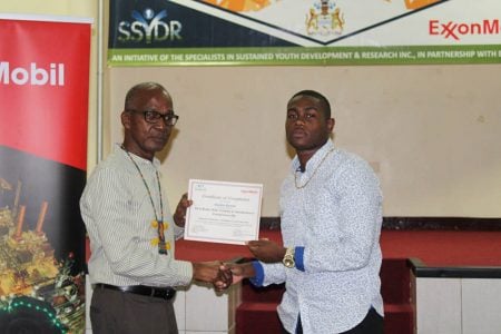 Minister of Labour Joseph Hamilton (left) handing out a certificate