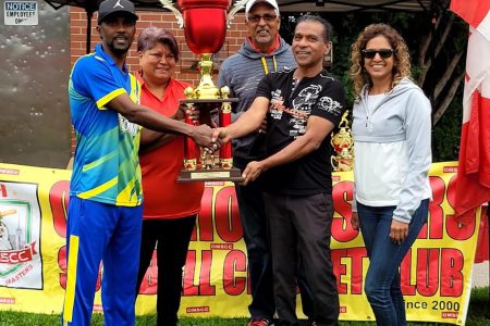 Roger Sunich of Trophy Stall hands over the winning trophy to Pegasus Storm skipper Troy Gobin in the presence of OMSCC Treasurer Kim Sue, Vice-president Hardatt Ramcharran and former executive Jas Mathura