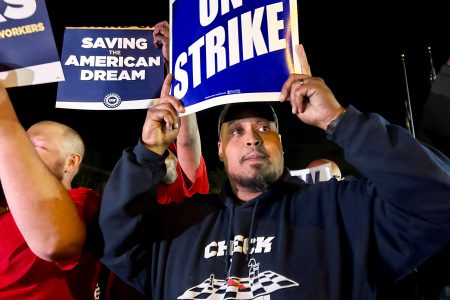 United Auto Workers hold up strike signs as their fellow union members walk out of the job at the Ford Michigan Assembly Plant in Wayne, Michigan, U.S., September 15, 2023. REUTERS/Eric Cox