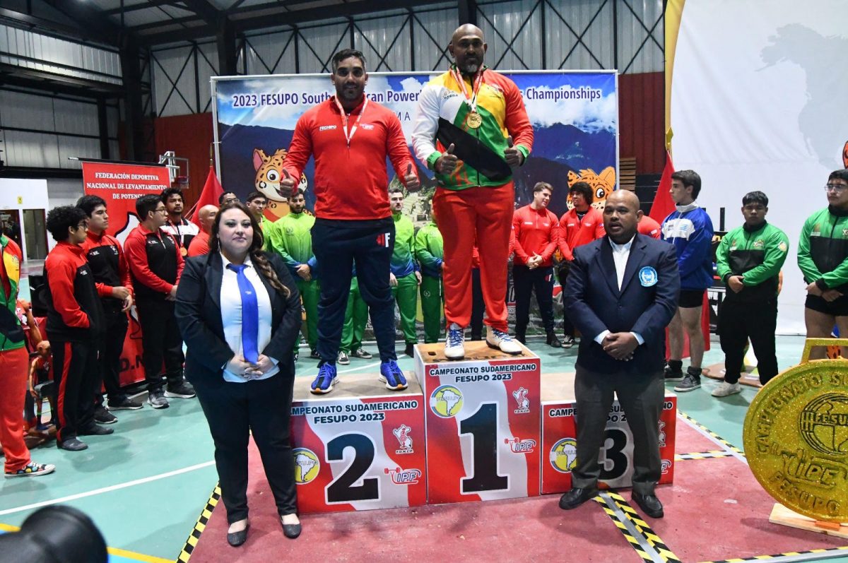 Mohamed Wazim shares the podium with second-placed Chilean, Bernado Ibenez. Guyanese Level 11 IPF Referee, Andrew Austin is at right.