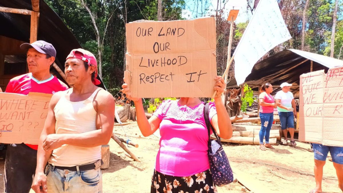 Villagers with placards protesting their forced removal from the mining area
