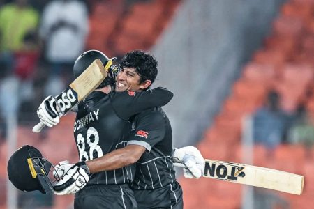 Embrace! New Zealand teammates Devon Conway (left) and Rachin Ravindra celebrate after thrashing defending champion England in the opening match of the 50-over World Cup