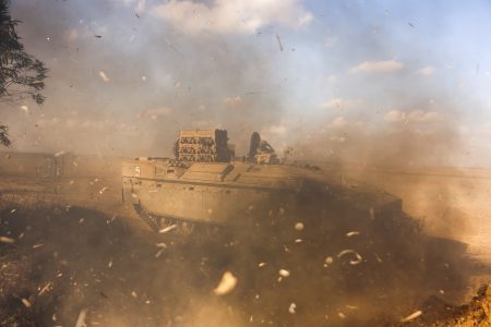 An Israeli Armoured Personnel Carrier (APC) is obscured as it whips up dust near Israel's border with the Gaza Strip, in southern Israel October 15, 2023. REUTERS/Ronen Zvulun