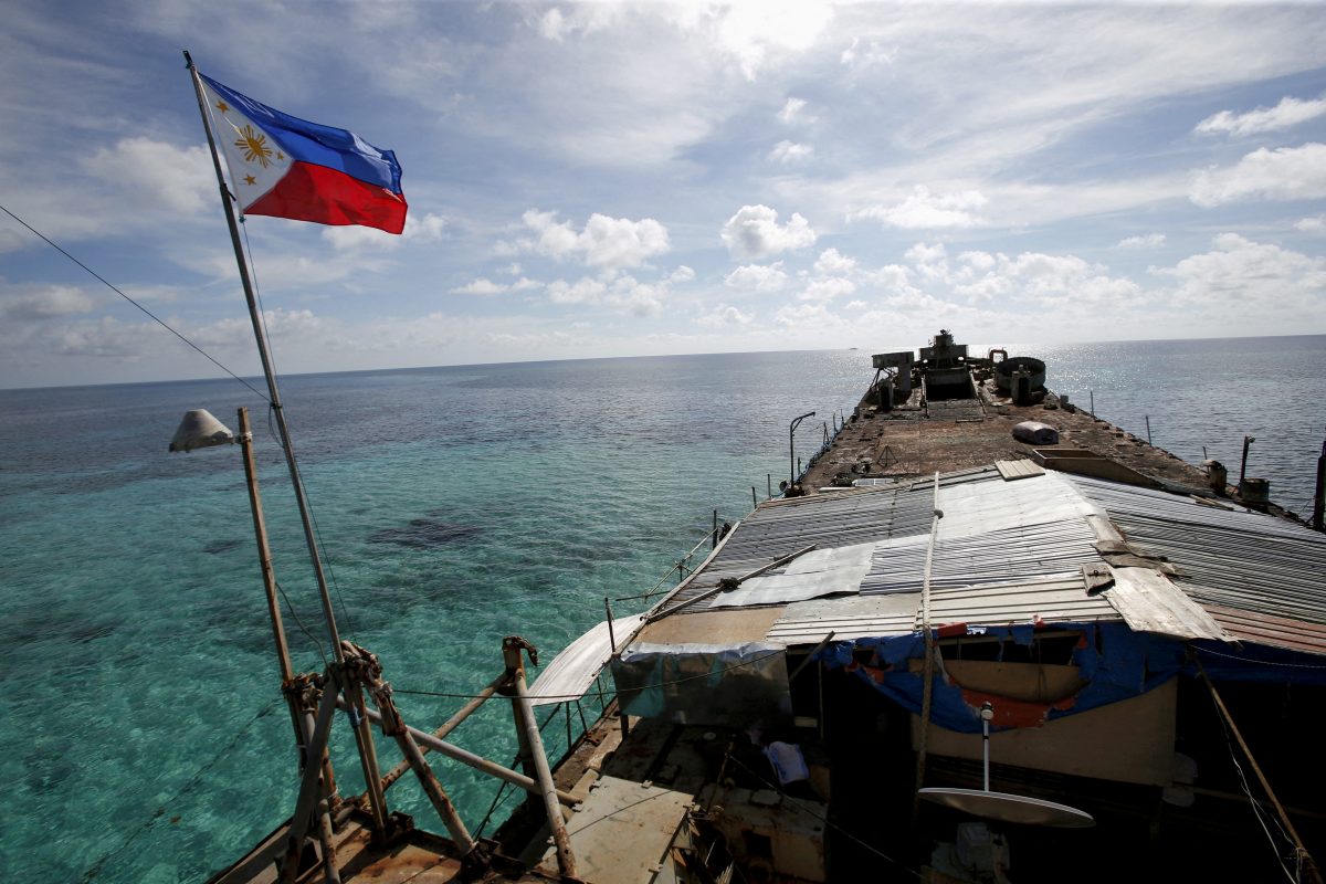 FILE PHOTO: FILE PHOTO: A Philippine flag flutters from BRP Sierra Madre, a dilapidated Philippine Navy ship that has been aground since 1999 and became a Philippine military detachment on the disputed Second Thomas Shoal, part of the Spratly Islands, in the South China Sea March 29, 2014. REUTERS/Erik De Castro/File Photo/File Photo