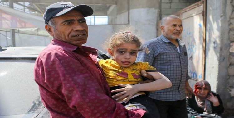 A Palestinian man carries a girl hurt in Israeli strikes in Gaza City October 15, 2023. REUTERS/Mutasem Murtaja Acquire Licensing Rights