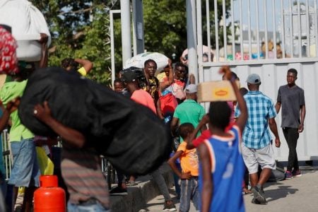 FILE PHOTO: Haitians carry personal belongings, as they cross the border between the Dominican Republic and Haiti, after Dominican President Luis Abinader announced an imminent total border shutdown amid a conflict over the construction of a water channel from a shared river, in Ouanaminthe, Haiti September 14, 2023. REUTERS/Octavio Jones/File Photo