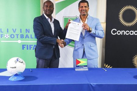 GFF President Wayne Forde (left) displaying the signed MoU with RMFC co-owner and President Steve Nijjar.
