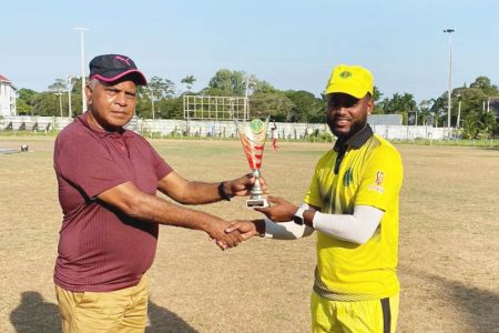 Malcolm Hubbard (right) receives his Man-of-the-Match prize from match referee, Moses Ramnarine.