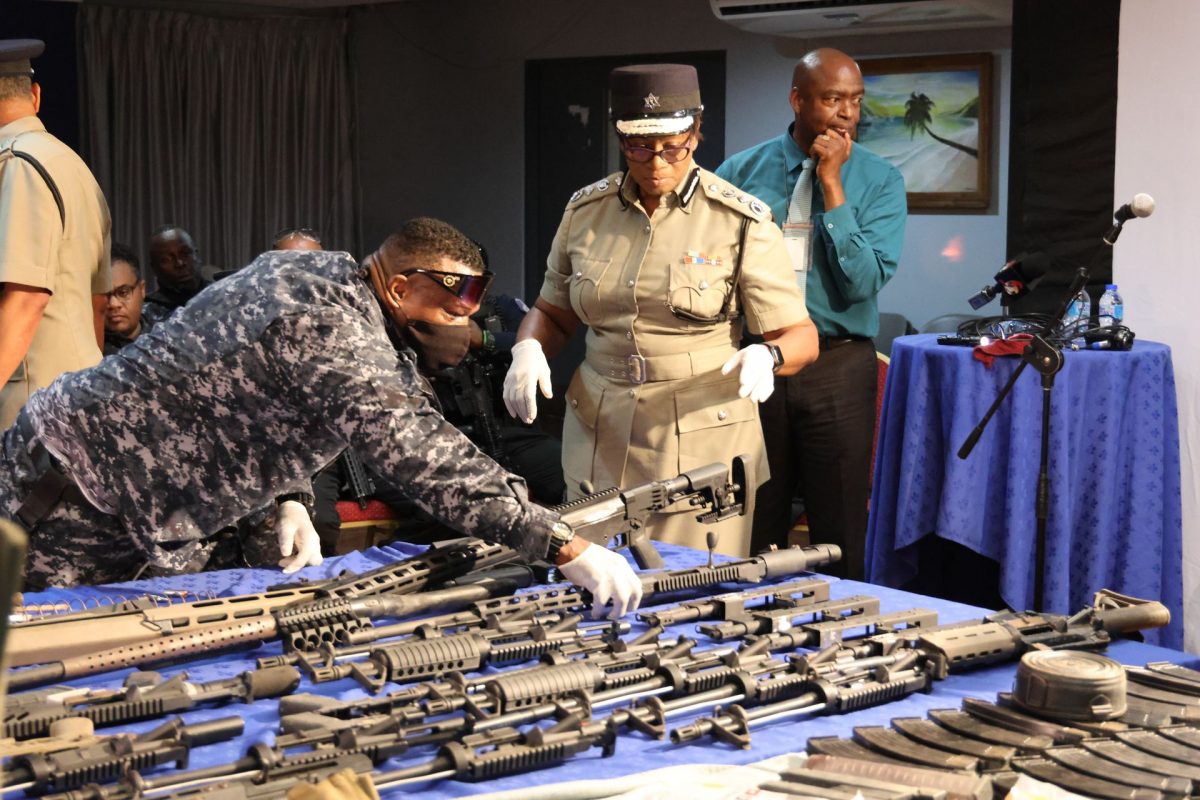 Commissioner of Police Erla Harewood-Christopher, right, and Senior Superintendent Roger Alexander look at one of the high-powered guns seized during the raid in Santa Cruz on Wednesday.