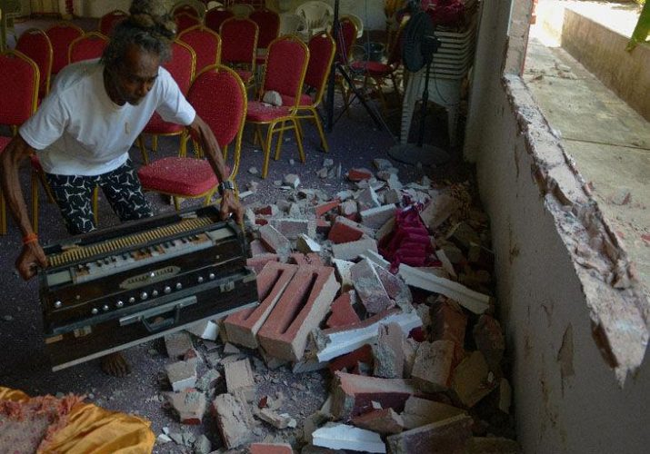 Pooran Nanan, of the Williamsville Hindu Temple, removes a harmonium yesterday from the debris of a ventilation wall which was destroyed. Vandals destroyed two walls of the place of worship to gain entry into the temple, which was vandalised on Saturday afternoon.