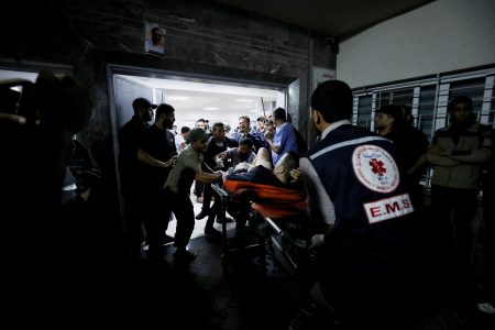 An injured person is assisted after an Israeli air strike hit At Al-Ahli Hospital, according to Gaza Health Ministry in Gaza City, Gaza Strip, October 17, 2023. REUTERS/Mohammed Al-Masri