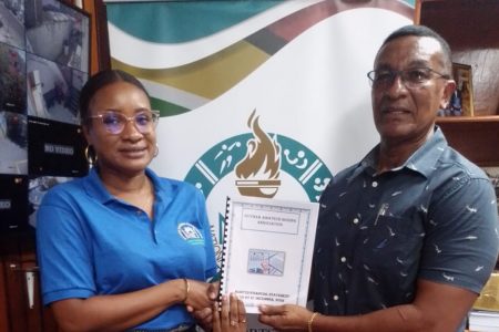 GBA secretary Stacy Corriea hands over the audited financial statement of the GBA to Chairman of the NSC Kashif Muhammad