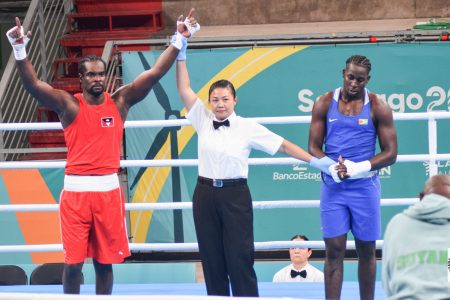 Guyana’s Emmanuel Pompey, right, can’t hide his disappointment after losing a split decision to Antigua’s Tabukuo Aska yesterday in the 96 kg round of 16 bout at the Pan American Games in Santiago, Chile.