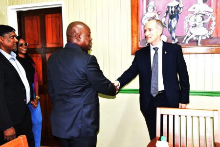 Alistair Routledge (right) greeting Opposition Leader Aubrey Norton at the meeting in September. (APNU photo)
