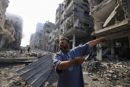 A Palestinian man indicates the destruction after Israeli air strikes on the Jabaliya refugee camp in Gaza on October 11, 2023. © Mahmud Hams, AFP 