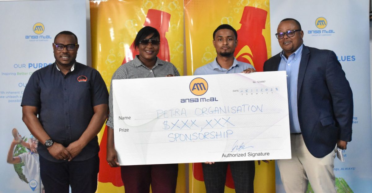 Petra Organisation member Jacqueline Boodie receives the sponsorship cheque from Non-Alcoholic Brand Manager Kristoff Stoll in the presence of Troy Mendonca (left), Co-Director of Petra Organisation, and Ansa McAl Managing Director Troy Cadogan.