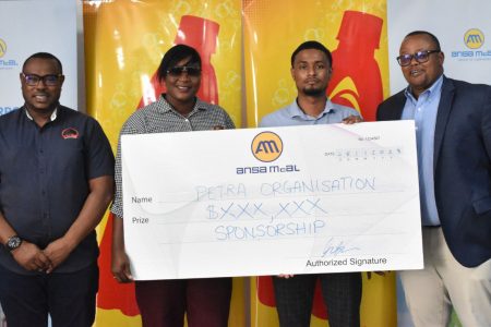 Petra Organisation member Jacqueline Boodie receives the sponsorship cheque from Non-Alcoholic Brand Manager Kristoff Stoll in the presence of Troy Mendonca (left), Co-Director of Petra Organisation, and Ansa McAl Managing Director Troy Cadogan.