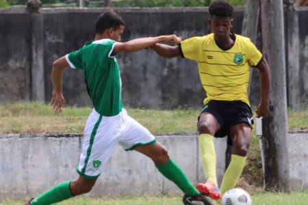 Ian Gomes (right) of Bartica is trying to evade a challenge from a Rupununi player