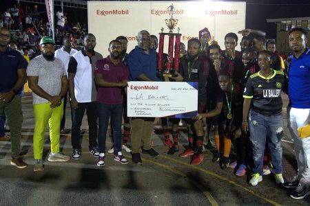 LA Ballers captain Tyric McAllister receiving the 1st place trophy and cheque from PM Mark Phillips and ExxonMobil Community Relations Advisor Ryan Hoppie in the presence
of teammates and tournament officials
