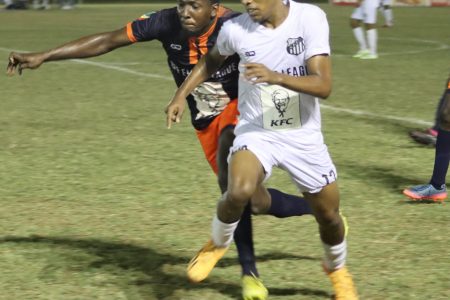 Brandon Solomon (right) of Santos trying to escape the pursuit of his Fruta Conquerors marker during their encounter in the KFC League Cup