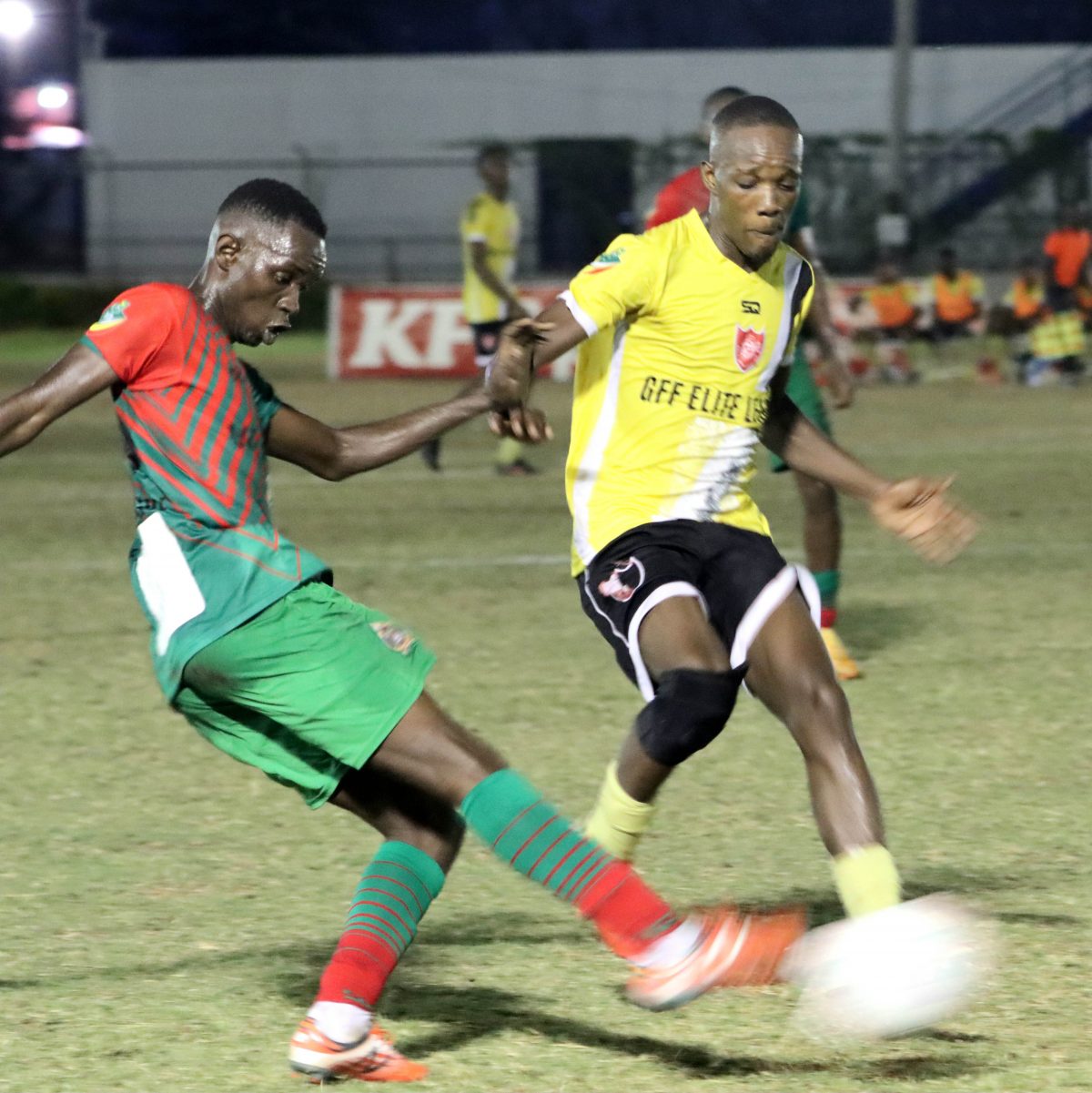 Darrell George of GDF (left) is attempting a clearance while being challenged by an Anns Grove player.