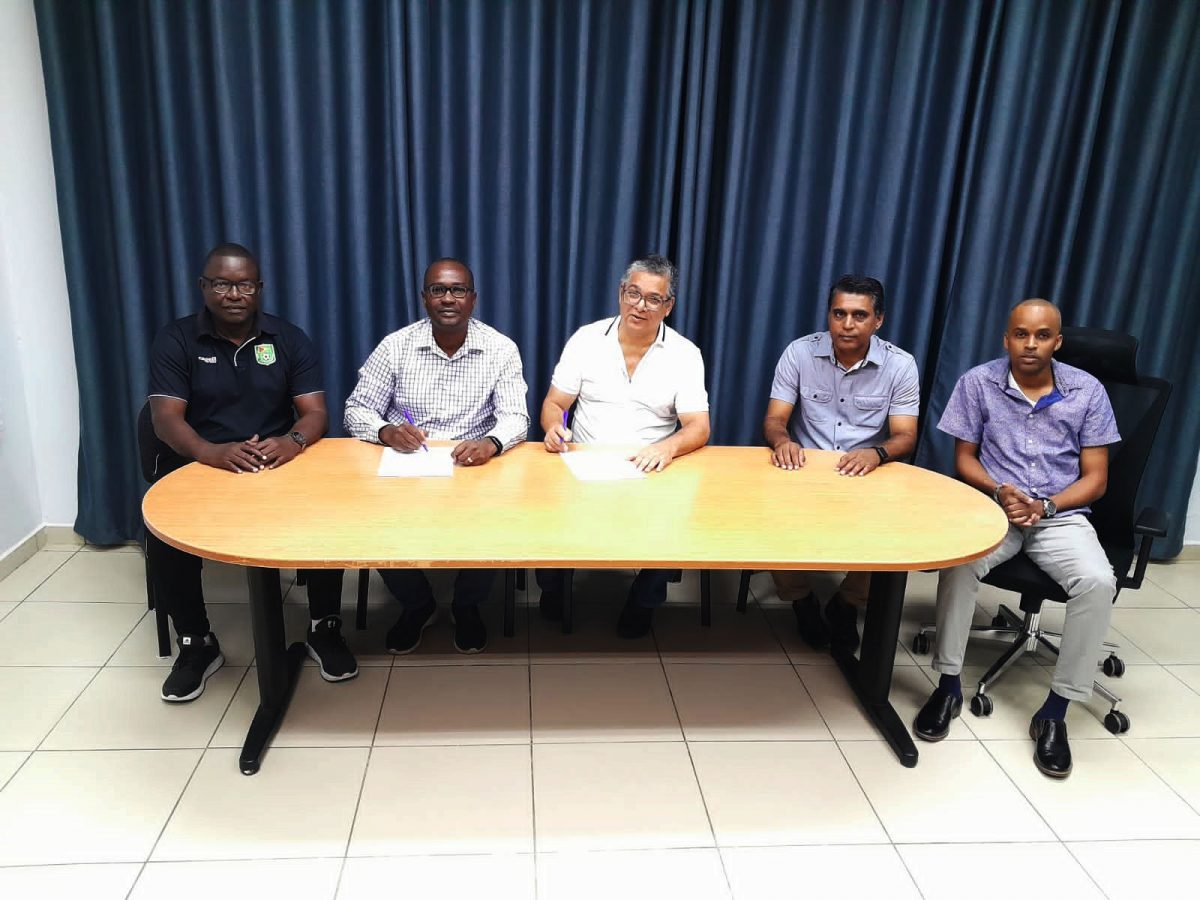 Inked! GFF President Wayne Forde (2nd from left) signing the agreement with his Surinamese counterpart John Krishnadath for the four-match Girls U17 international series. Also in the photo are GFF Technical Director Bryan Joseph (1st from left), his Suriname counterpart Biswajeet Kali (4th from left), and Suriname Technical Director Mitchel Kisoor.