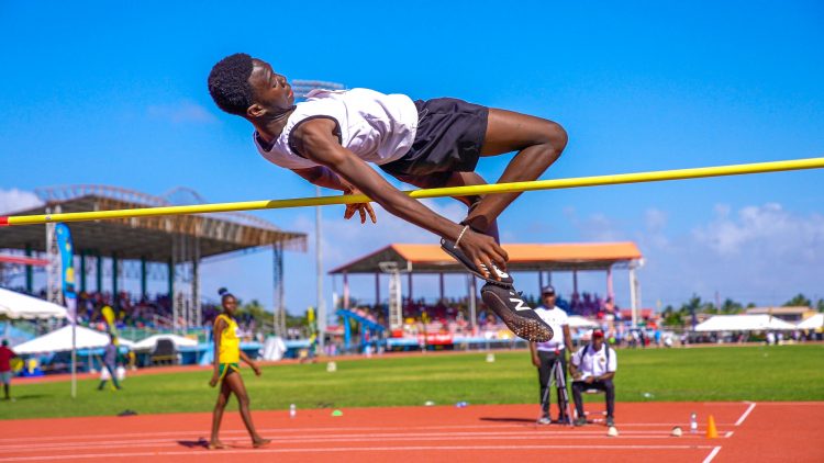 Romarion Wolfe sails over the bar in the high jump in the Boys’ U-14 division to register a new record of 1.66m, beating the previous record of 1.63 m (Photo compliments of the Ministry of Education)
