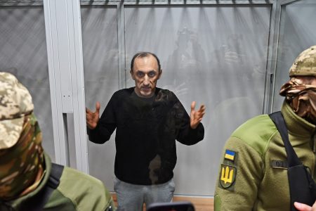 Col. Roman Chervinsky appears in a glass room during a hearing in the Shevchenko District Court in Kyiv on Oct. 10, 2023. (Oleg Bohachuk for The Washington Post)
