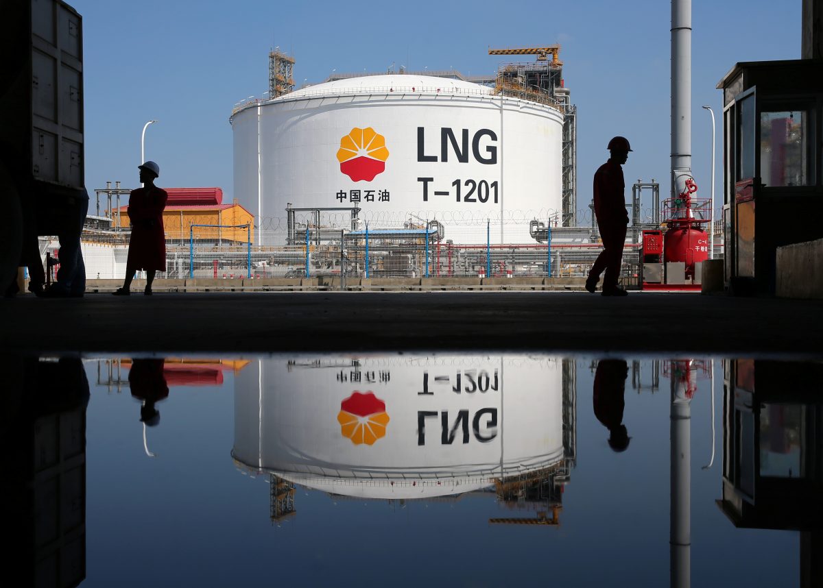 FILE PHOTO: A liquified natural gas(LNG) storage tank and workers are reflected in a puddle at PetroChina’s receiving terminal at Rudong port in Nantong, Jiangsu province, China September 4, 2018. REUTERS/Stringer/File Photo