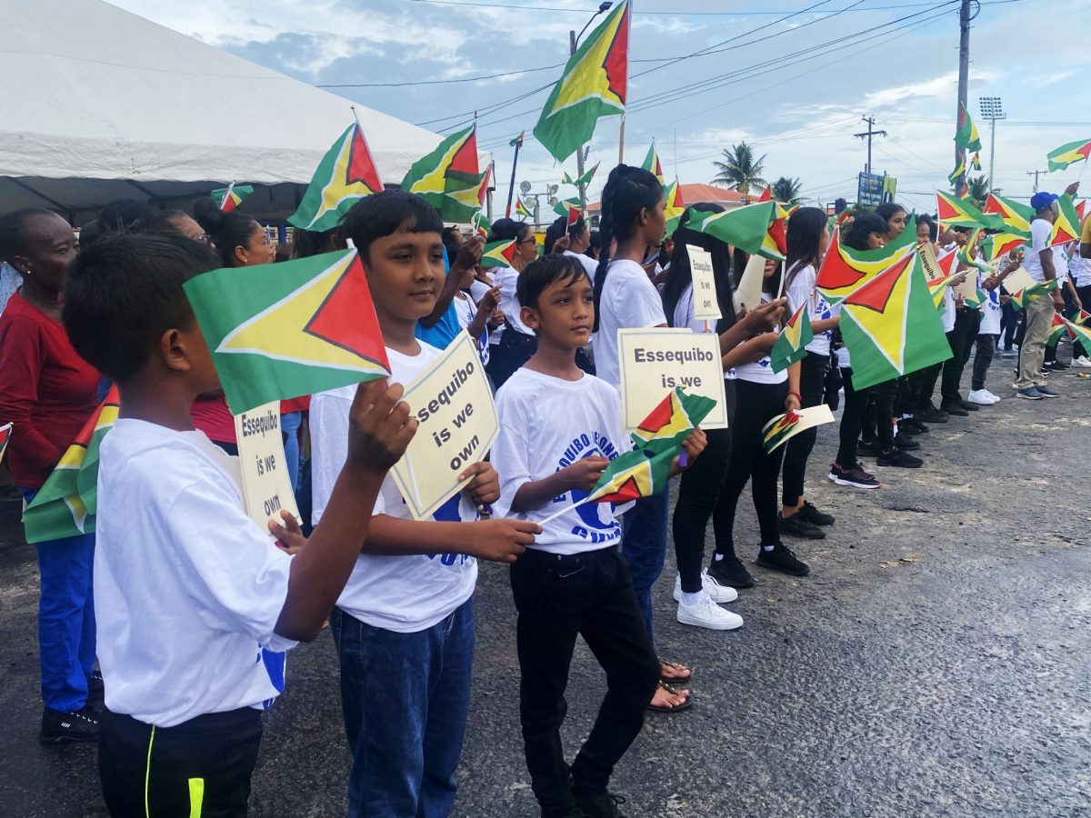 Children with plac cards reiterating Essequibo belongs to Guyana during the meeting