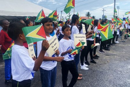 Children with plac cards reiterating Essequibo belongs to Guyana during the meeting