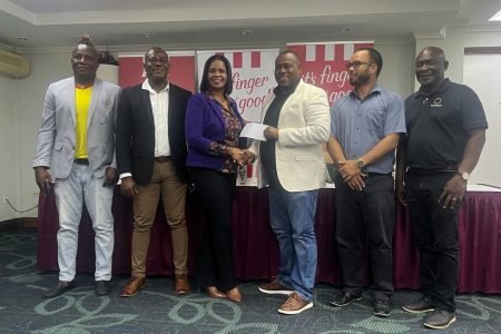 KFC Marketing Manager Pamela Manasseh (centre) hands over the sponsorship package to Petra’s Troy Mendonca while Petra Organisation Referee Consultant Wayne Griffith (1st from left), Assistant Director of Sports Franklin Wilson (2nd from left), Nicholas Fraser (3rd from left), Administrator of the Allied Arts Unit, and GFF Director of Competitions Troy Peters look on.