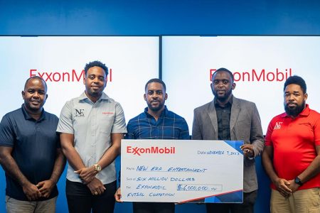 Ryan Hoppie (third from left), ExxonMobil Guyana’s Community Relations Advisor for Public and Government Affairs, hands over the sponsorship check to Aubrey Major Jr., Co-Director of New Era Entertainment.