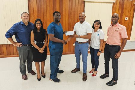 Kevon David (3rd from left), junior vice president of the Guyana Rugby Football Union, received a cheque from the president of the GOA, Godfrey Munroe. Looking on from left to right are G.O.A.’s Vice President, Philip Fernandes, Secretary-General Vidushi Persaud-McKinnon, Assistant Secretary Emelia Ramdhani, and Treasurer Garfield Wiltshire
