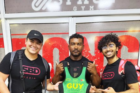 Carlos Peterson-Grifith (centre) becomes the first Guyanese to be outfitted with
official SBD apparel customised with the nation’s colours. He is flanked by SBD’s Justin Nutt (left) and Zalim Farooqui, who arrived in Guyana recently from the
USA to film the power-lifter as part of the ‘Road to Sheffield’ documentary.