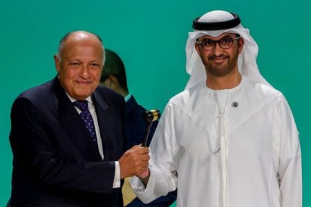 COP27 President Sameh Shoukry (L) hands over the gavel to COP28 president Sultan Ahmed Al Jaber during the opening ceremony of the COP28 United Nations climate summit in Dubai on November 30, 2023.