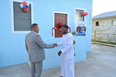 Minister of Housing and Water,  Collin D Croal (left) with one of the recipients (CH&PA photo)