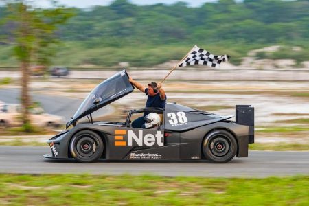 ENet CEO Vishok Persaud makes a celebratory lap with the chequered flag after winning the
marquee Group 4/Unlimited race on Sunday at the ENet Caribbean Clash of Champions at the South Dakota Circuit. (Photo: GMR&SC)
