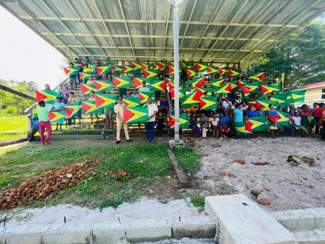 Residents holding up Guyana flags (Police photo)