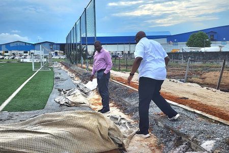 Howard McIntosh (right), Head of One CONCACAF and Caribbean Projects, assesses the work underway at the National Training Centre in Providence alongside GFF President Wayne Forde
