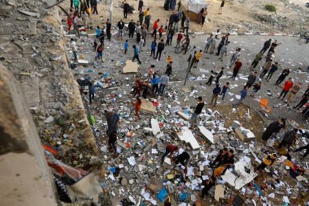 People walking among debris at the site of an Israeli strike on the apartment building, in Khan Younis in south Gaza, on Nov 18. PHOTO: REUTERS