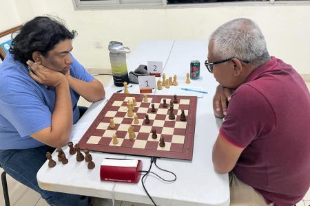 Candidate Master Taffin Khan (left) engaged in a four-hour long duel with Loris Nathoo in the eighth round of the Ram & McRae sponsored National Open Chess Championship. Khan went undefeated in eight rounds to be crowned overall winner.
