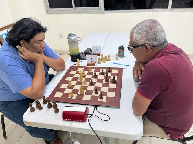 Candidate Master Taffin Khan (left) engaged in a four-hour long duel with Loris Nathoo in the eighth round of the Ram & McRae sponsored National Open Chess Championship. Khan went undefeated in eight rounds to be crowned overall winner.
