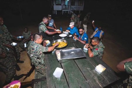 President Irfaan Ali (second from right) and Chief of Staff of the Guyana Defence Force, Brigadier Omar Khan (right) having dinner last night at the border with soldiers. (Office of the President photo)