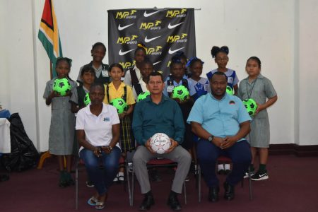 Players from some of the participating teams display the donated footballs at the team briefing and distribution exercise at the National Library. Sitting at the centre L-R (front) are Petra Organisation's Lavern Fraser, Deputy Chief Education Officer (Hinterland) Marti De Souza and Petra Co-Director Troy Mendonca.
