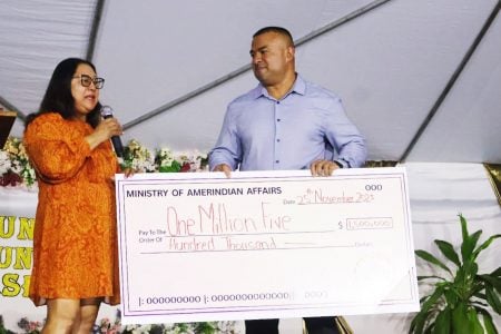 Minister of Amerindian Affairs Pauline Sukhai presenting the cheque to RCCI President Orlando Wong 