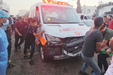 Palestinians pull an ambulance after a convoy of ambulances was hit, at the entrance of Shifa hospital in Gaza City, November 3, 2023. Photo: REUTERS/Anas al-Shareef...