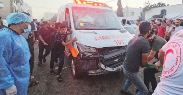 Palestinians pull an ambulance after a convoy of ambulances was hit, at the entrance of Shifa hospital in Gaza City, November 3, 2023. Photo: REUTERS/Anas al-Shareef...