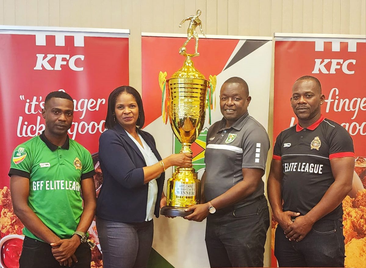 KFC Marketing Manager Pamella Manasseh presents the championship
trophy to GFF Technical Director Bryan Joseph in the presence of GDF
captain Kennard Simon (left) and Assistant Coach Selwyn Prince.
