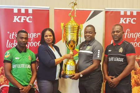 KFC Marketing Manager Pamella Manasseh presents the championship
trophy to GFF Technical Director Bryan Joseph in the presence of GDF
captain Kennard Simon (left) and Assistant Coach Selwyn Prince.
